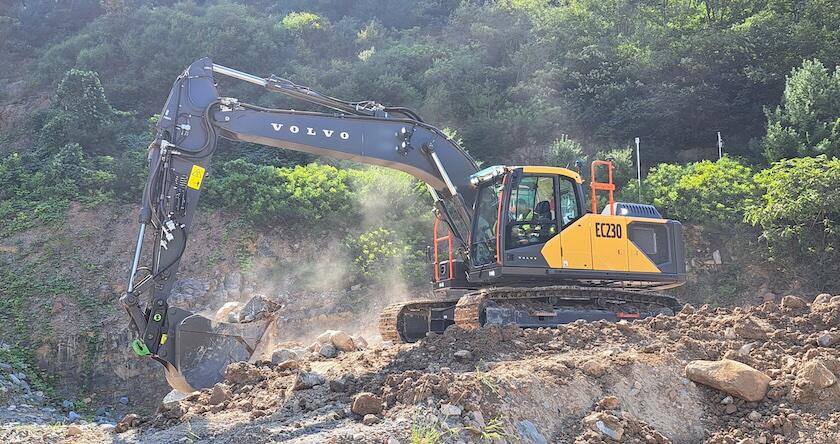 A new Volvo EC230 excavator moving dirt and rock on a jobsite.