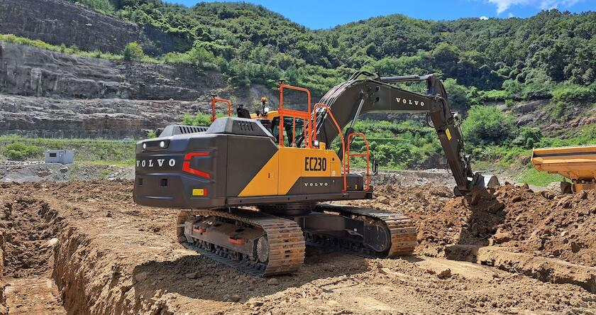 A new Volvo crawler excavator loading dirt into an articulated haul truck.